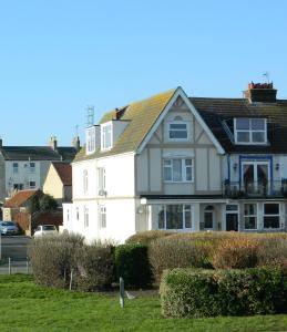 een wit huis met een zwart dak bij 'Harbour View' on the river by Gorleston's award winning beach - Pet free! in Gorleston-on-Sea