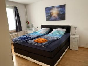ein kleines Schlafzimmer mit einem Bett mit blauer Bettwäsche in der Unterkunft Wohnung in Bern