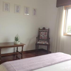 ein Schlafzimmer mit einem Bett, einem Stuhl und einem Tisch in der Unterkunft myninho in Vila Nova de Gaia