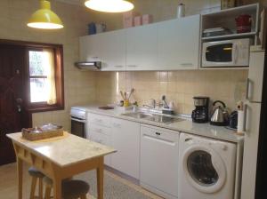 a kitchen with a sink and a washing machine at myninho in Vila Nova de Gaia