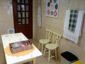 eine Küche mit einem Tisch, 2 Stühlen und einem Handtuch in der Unterkunft myninho in Vila Nova de Gaia