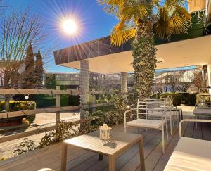 a patio with tables and chairs and a palm tree at Hotel Santacroce Meeting in Sulmona