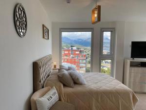 a bedroom with a bed with a view of a city at Infinity View Pent House III in Ushuaia