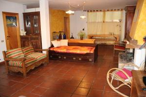 a living room with a bed and a chair at Villa Ca' dell'Olmo in Monteciccardo