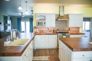a kitchen with white cabinets and a sink at Sierra Ranch - A Yosemite Retreat in Mariposa