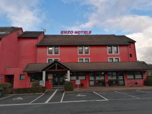 um edifício vermelho com um hotel em Enzo Hotels Vierzon by Kyriad Direct em Vierzon