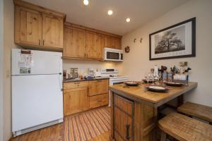 uma cozinha com um frigorífico branco e armários de madeira em Hi Country Haus - 13-15 Condo em Winter Park