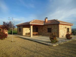 Casa Rural Escapada Rústica Teruel في تيرويل: منزل حجري صغير مع شرفة وفناء