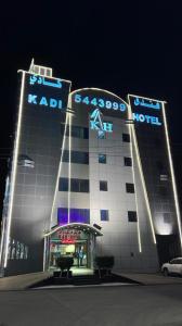 a building with the name of a hotel at night at Kadi Hotel in Najran