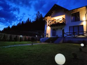 una casa con luces en el patio por la noche en Bucovina Sky View, en Gura Humorului 79 fotos más