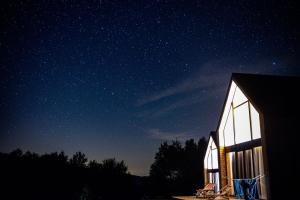 Un granero de noche con un cielo estrellado en Dolina Gwiazd, en Ropienka