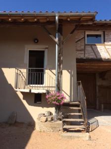 una casa con balcón y una escalera delante de ella en Studio Aux 2 Chouettes en Saint-Didier-sur-Chalaronne