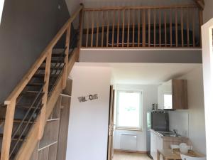 uma escada num quarto com uma cozinha em Studio Aux 2 Chouettes em Saint-Didier-sur-Chalaronne