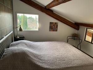 a bedroom with a large bed with a window at Clos du Cardinal in L'Isle-sur-la-Sorgue