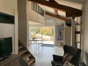 a living room with a television and a table with chairs at Clos du Cardinal in L'Isle-sur-la-Sorgue