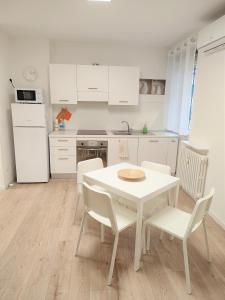 una cucina bianca con tavolo e sedie bianchi di Casa Gege Pavia Città a Pavia