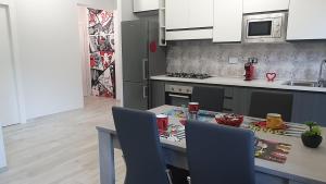 a kitchen with a table and chairs and a kitchen with white cabinets at Alloggio Turistico Ostia in Lido di Ostia
