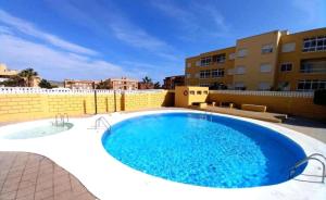 une grande piscine sur le toit d'un bâtiment dans l'établissement El Médano Lagos de Miramar apartamento, à El Médano