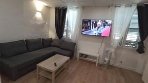 a living room with a couch and a flat screen tv at Studio Neuf climatisé Centre ville #5 in Toulon