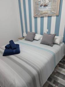 cama grande con pared de rayas azul y blanco en Nueva Europa apartamentos, en Maspalomas