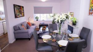 a living room with a table and a blue couch at FREE parking, Central Location,1 Bedroom Apartment near Tattersalls in Newmarket +11 photos