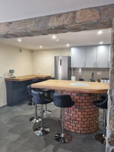 a kitchen with a counter and bar stools at MŁYŃSKA 8 Opole-Górki in Opole +14 photos