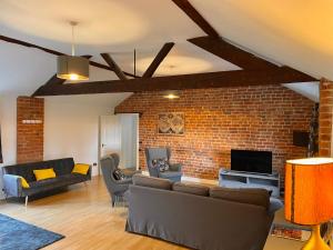 a living room with couches and a brick wall at Hayes Suite in Oswestry