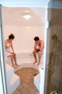 deux hommes sont assis dans une baignoire dans l'établissement App 613 Panoramic Hohegeiß Terrassenhaus, à Hohegeiss