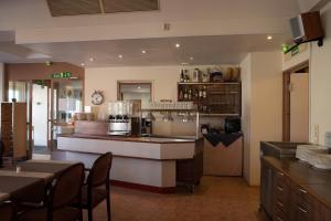 a restaurant with a counter and a table and chairs at Hotel Aakenus in Rovaniemi
