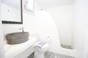 a bathroom with a sink and a tub on a toilet at Crystal View Mykonos in Mikonos