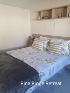 a bedroom with a bed with pillows on it at Pine Ridge Retreat With FREE GOLF and Air Conditioning in Morpeth