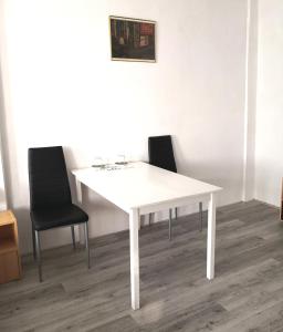 a white table and two chairs in a room at Zimmervermietung Schöne Gasse 6 in Freiberg