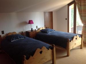 een slaapkamer met 2 bedden en een raam bij Les Grangettes 2 - DUPLEX - WIFI gratuite in Les Carroz d'Araches