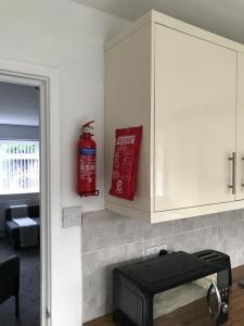 a kitchen with a microwave and a red fire extinguisher at Property Hunter 23 in Darlington