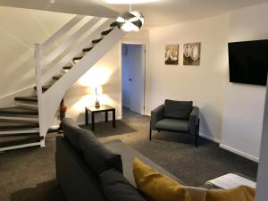 sala de estar con sofá, silla y escaleras en Property Hunter 23 en Darlington