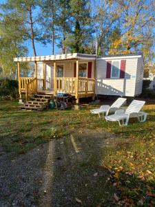 a tiny house with two chairs and a porch at mobil home 32 m² 4/6p in Onzain