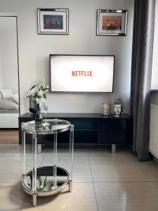 ein Wohnzimmer mit einem TV und einem Tisch in der Unterkunft See U in Szczecin -Under the Castel in Stettin