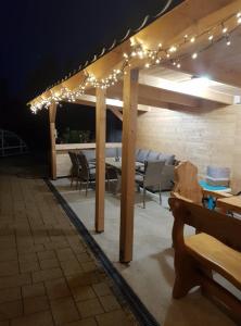 a patio with a table and chairs and lights at GOLDENVENDÉGHÁZ in Balatonszabadi