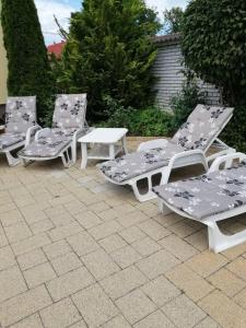 a group of four lawn chairs sitting on a patio at GOLDENVENDÉGHÁZ in Balatonszabadi