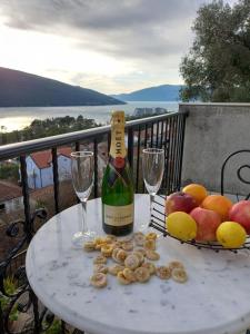 una mesa con una botella de vino y una cesta de fruta en House Hill Star Kumbor en Kumbor