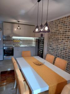 a kitchen with a dining table with chairs and a brick wall at House Hill Star Kumbor in Kumbor