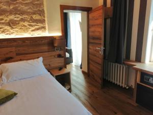 sypialnia z białym łóżkiem i drewnianą ścianą w obiekcie Hotel Firenze w mieście Fanano