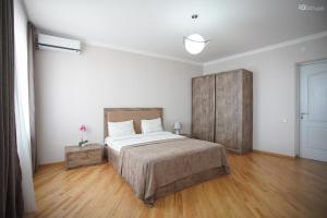 1 dormitorio con 1 cama grande y suelo de madera en Zurabashvili Guest House en Sighnaghi