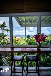 a vase of flowers sitting on a table in front of a window at Papaya Suite at Sunset Serenade in Enighed