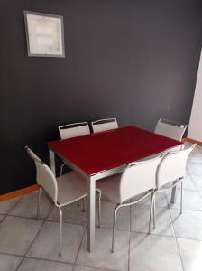 uma mesa de jantar vermelha e cadeiras num quarto em Casa Baia Azzurra em Bergeggi