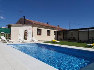 a swimming pool in front of a house at La Morada de los Olmos in Segovia