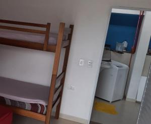 a bedroom with a bunk bed and a door to a bathroom at Casa para temporada, Centro de Ubatuba in Ubatuba