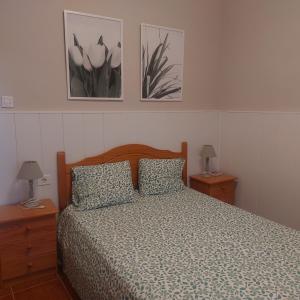 a bedroom with a bed and two pictures on the wall at Candela's House in Barranco Hondo