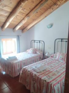 um quarto com 2 camas e uma janela em Casa Rural El Cortijo Nuevo, en El Cerezo em El Cerezo