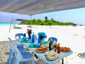 a table on the beach with food on it at VIVA Beach Maldives in Hangnaameedhoo